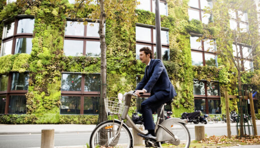 Man riding bike in front of vertical garden