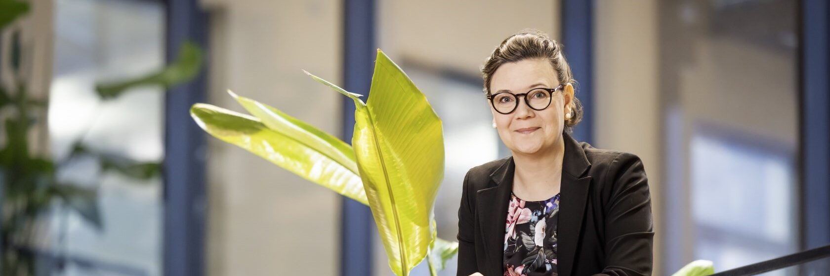 Piia Pessalan kuva, Piia nojaa lasiseen porraskaiteeseen