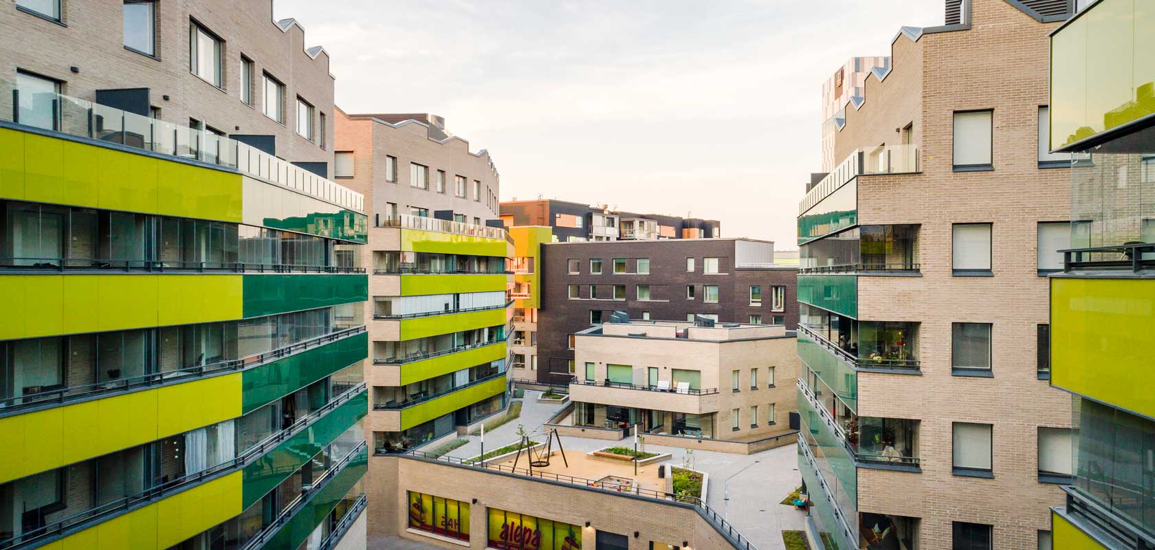 Moderni asuinkompleksi, jossa on useita monikerroksisia kerrostaloja. Rakennuksissa on nykyaikainen muotoilu, suuret ikkunat ja parvekkeet.