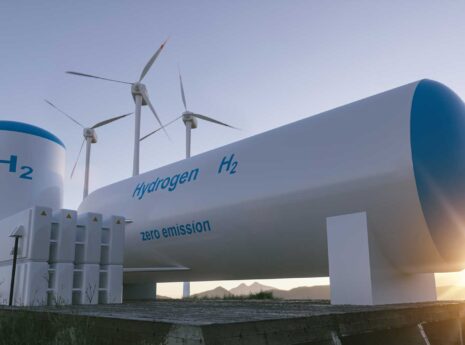 Hydrogen storage tanks in front and wind mills behind, early sunrise