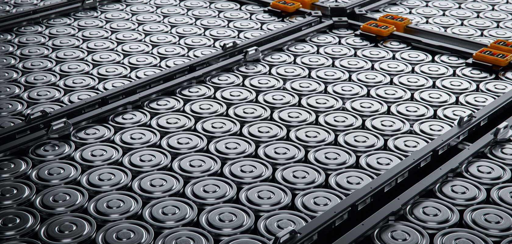 Lähikuva suuresta määrästä sylinterimäisiä akkuja, jotka on järjestetty ruudukkomuodossa.