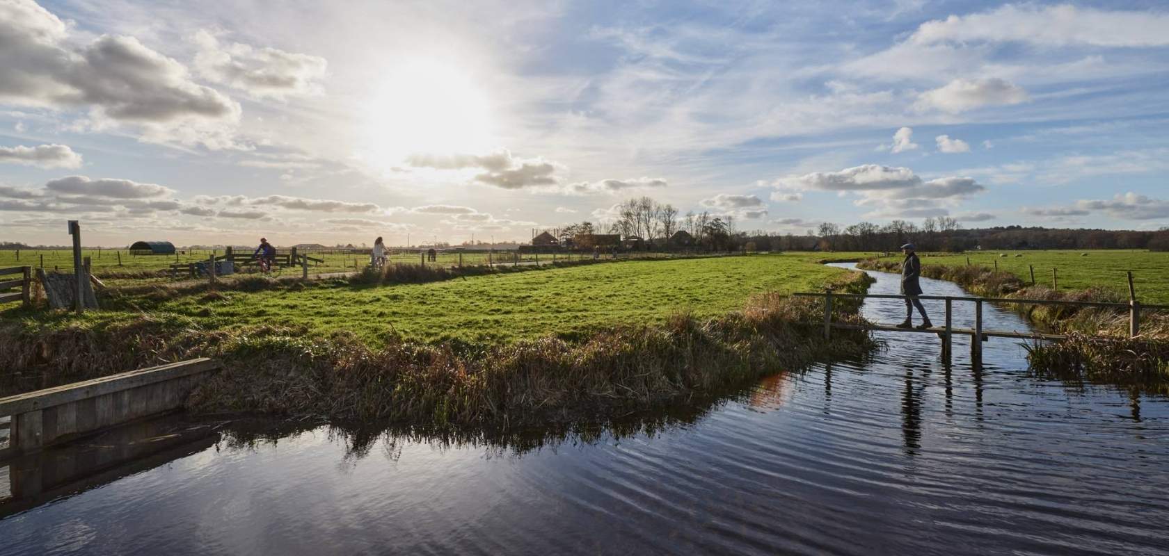 Niittymäinen pelto, jonka keskellä virtaa pieni joki