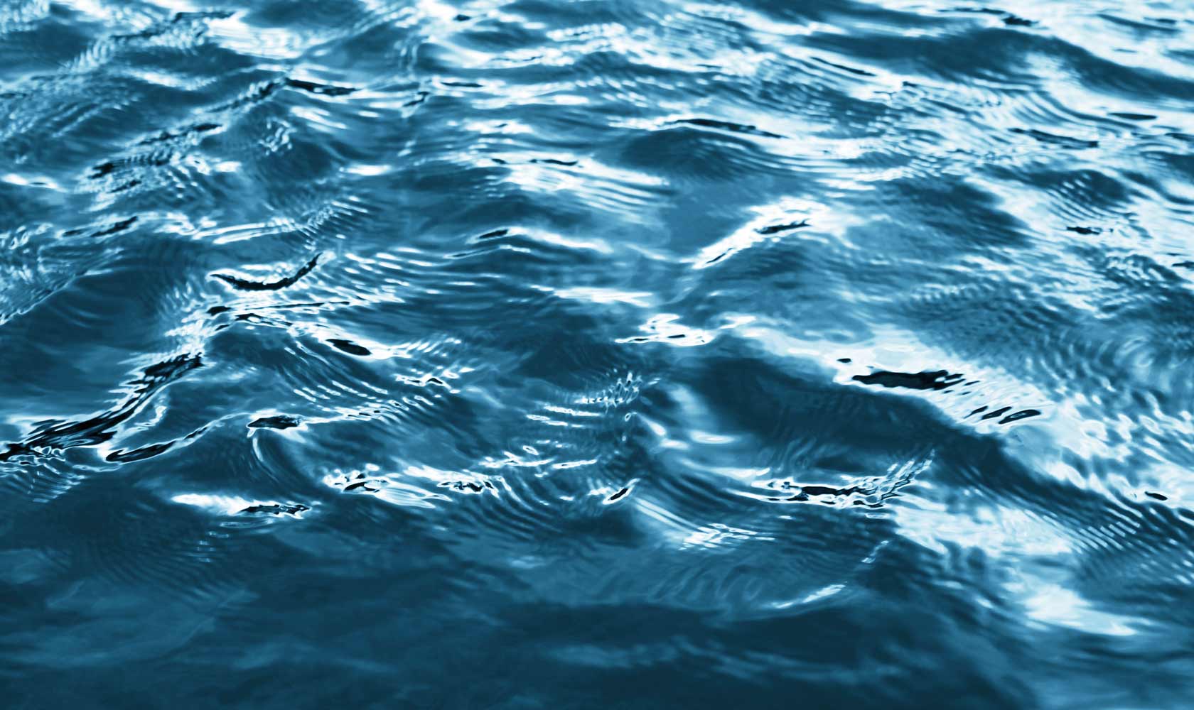 Close-up of rippling water surface with reflections.