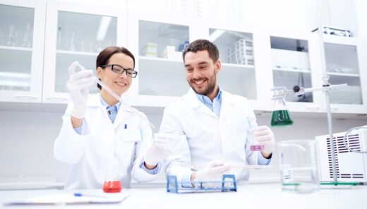Scientists conducting experiments in a modern laboratory, focusing on beakers with colorful liquids.