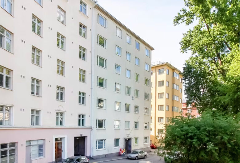 Kerrostaloja ja puita rauhallisella kadulla.