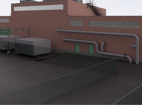 Industrial building with red brick exterior, pipes, and adjacent structures, labeled "loiste."