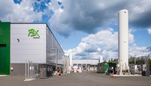 P2X yrityksen teollisuusrakennus kirkkaan taivaan alla.