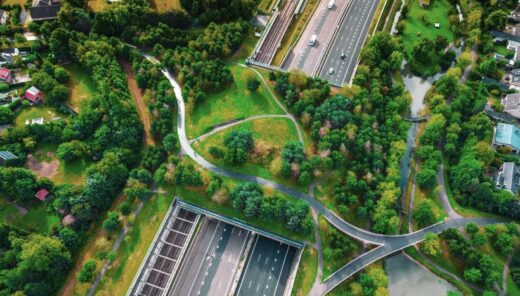 Ilmakuva moottoritiestä, joka menee tunneliin ja tunnelin päällä on vihreä puisto, puistossa kävelytie ja puita sekä tilaa monimuotoiselle luonnolle.