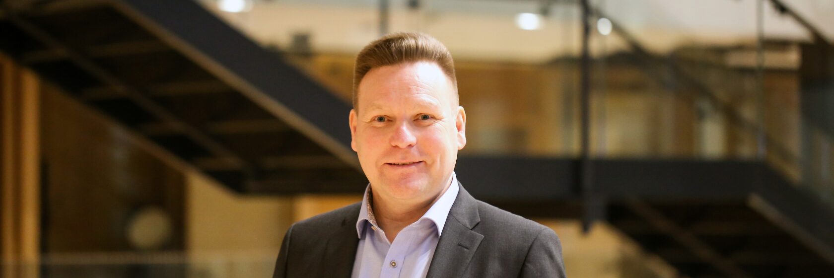 Mikko Turunen hymyilee aulatilassa.