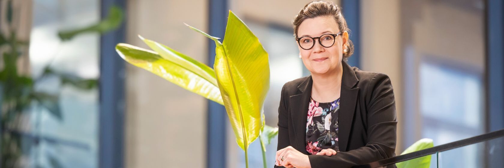 Photo by Piia Pessala, Piia leaning on a glass stair railing