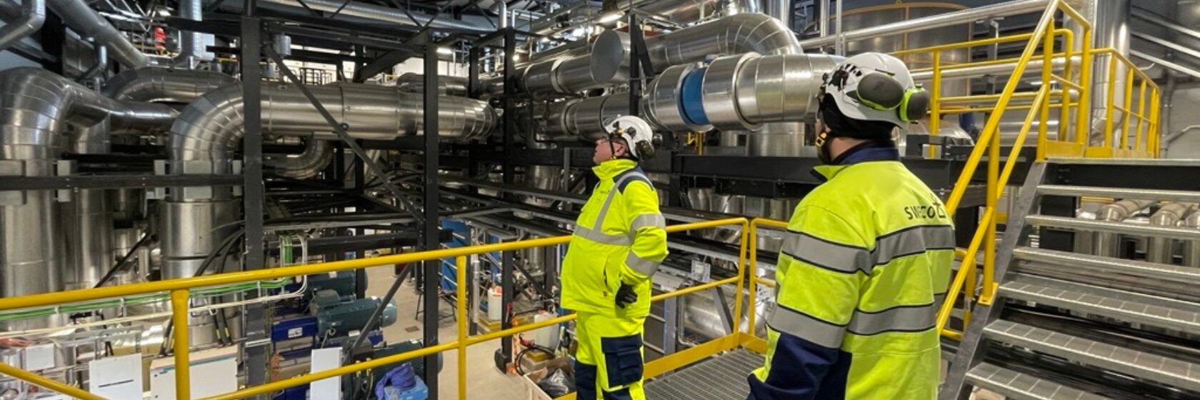 Swecon työntekijöitä katselemassa lämpöpumppuhallia.