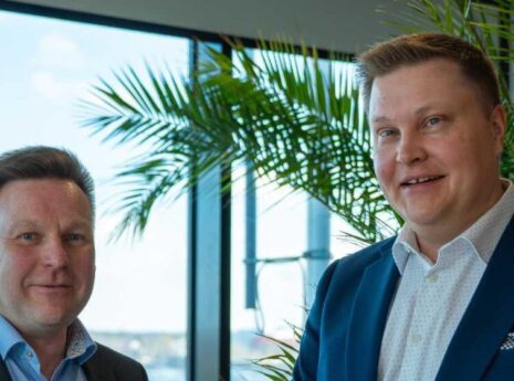 Swecon toimialajohtajat Mikko Turunen ja Tuomas Salminen valoisan ikkunan edessä hymyilemässä.