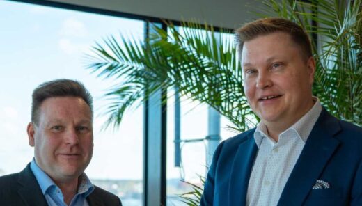 Swecon toimialajohtajat Mikko Turunen ja Tuomas Salminen valoisan ikkunan edessä hymyilemässä.