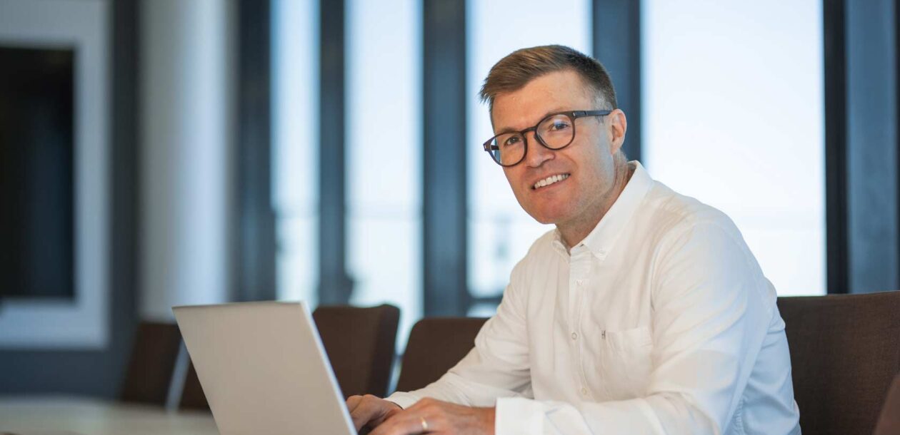 Valokuva Kalevi Saarelasta läppärillä.
