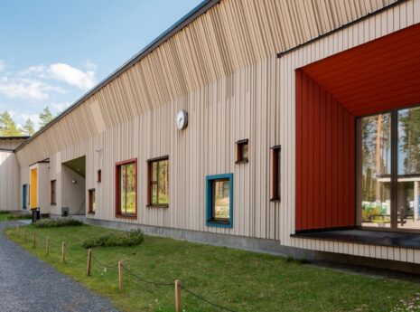 moderni koulurakennus värikkäillä ikkunoilla ja pihatiellä Suomessa