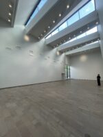 Spacious modern art gallery with skylights, white walls, and tiled floor interior